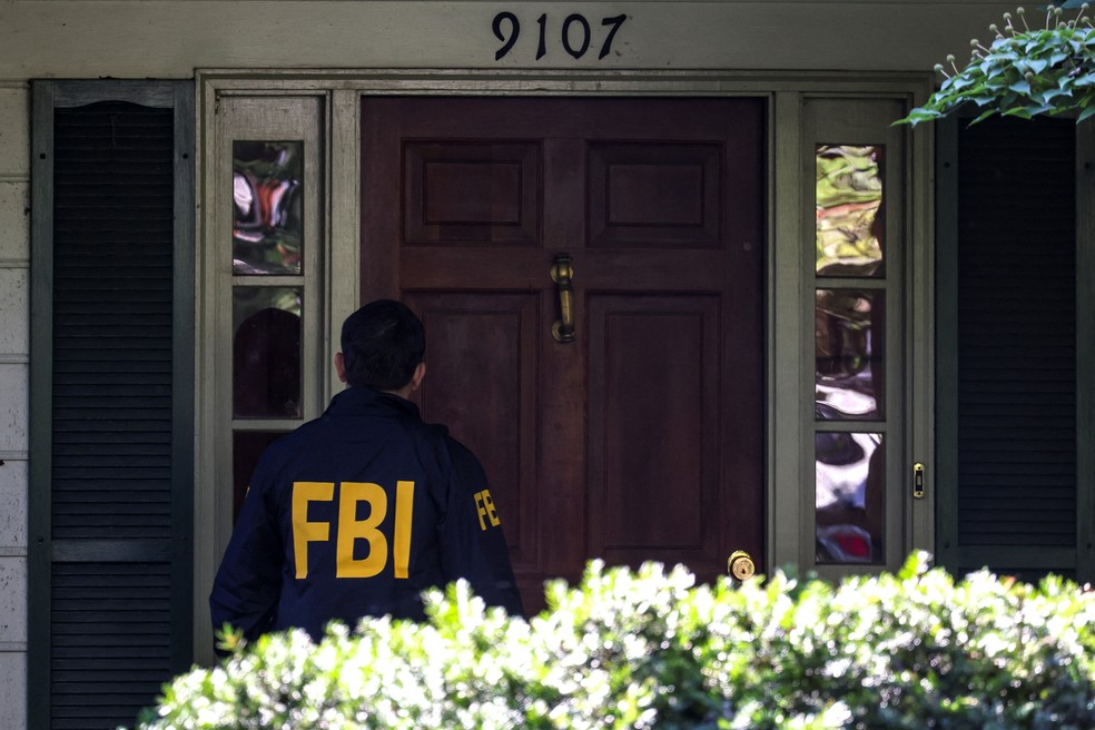 Agente do FBI na porta da casa do ex-agente de Segurança Nacional dos EUA， John Bolton， durante operação de buscas em sua residência， em 22 de agosto de 2025. — Foto: Tasos Katopodis/ Reuters